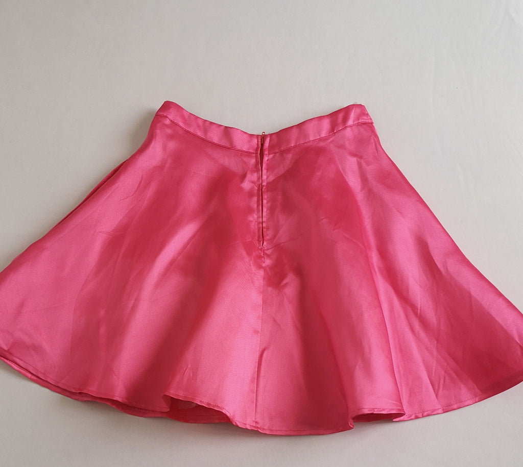Blusa asimétrica y falda campana con bolsas a los lados