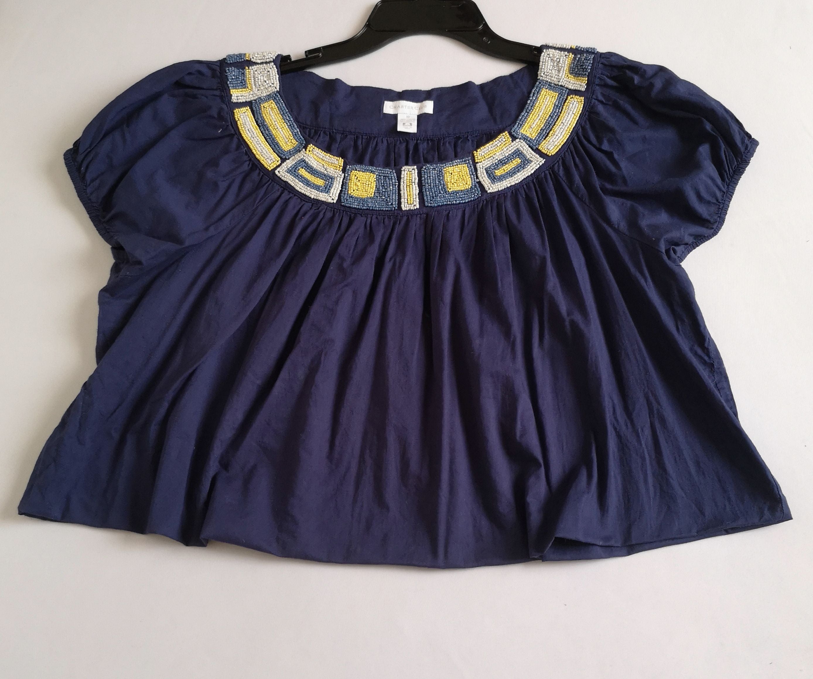 Blusa corta bordada y jeans rasgado