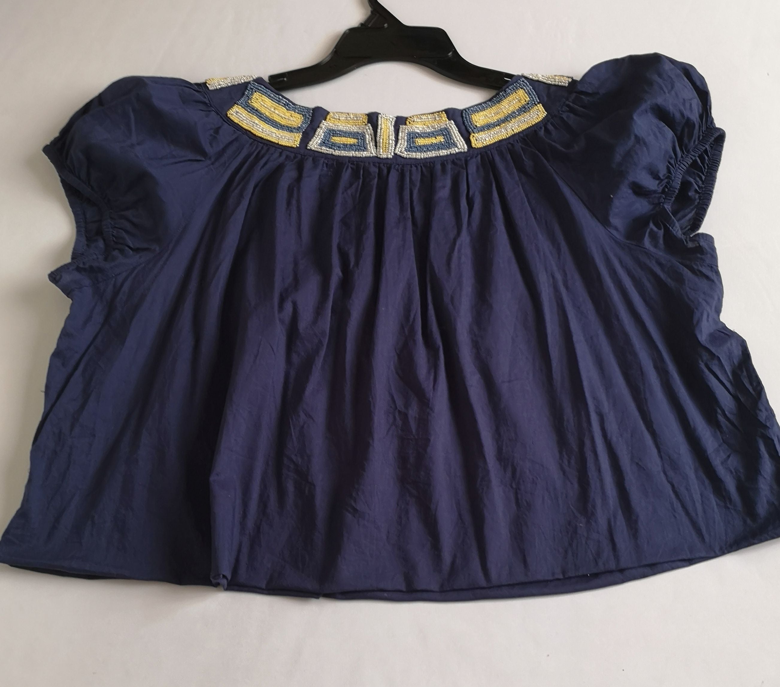 Blusa corta bordada y jeans rasgado