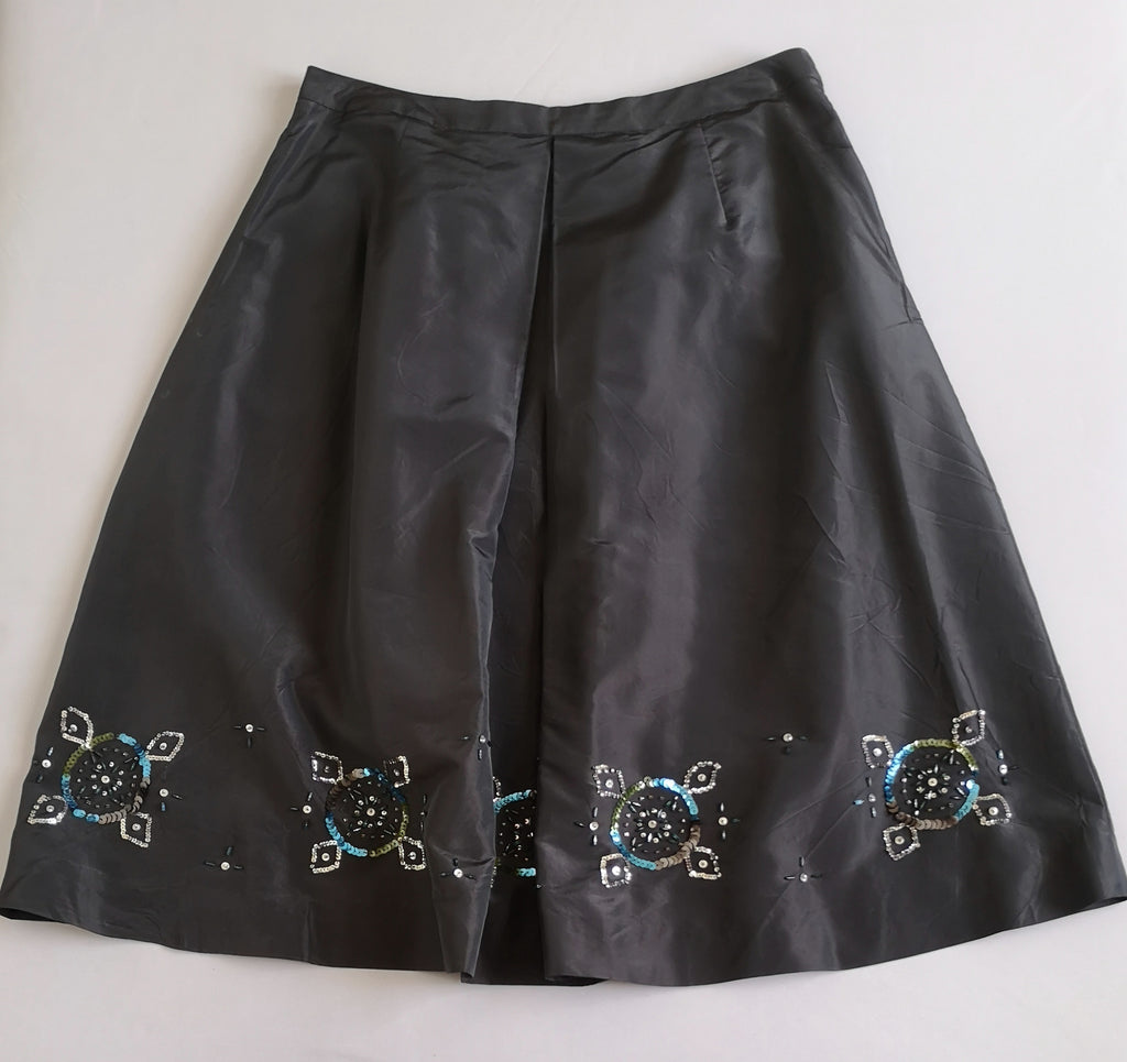Falda a la rodilla y blusa con bolsas adelante